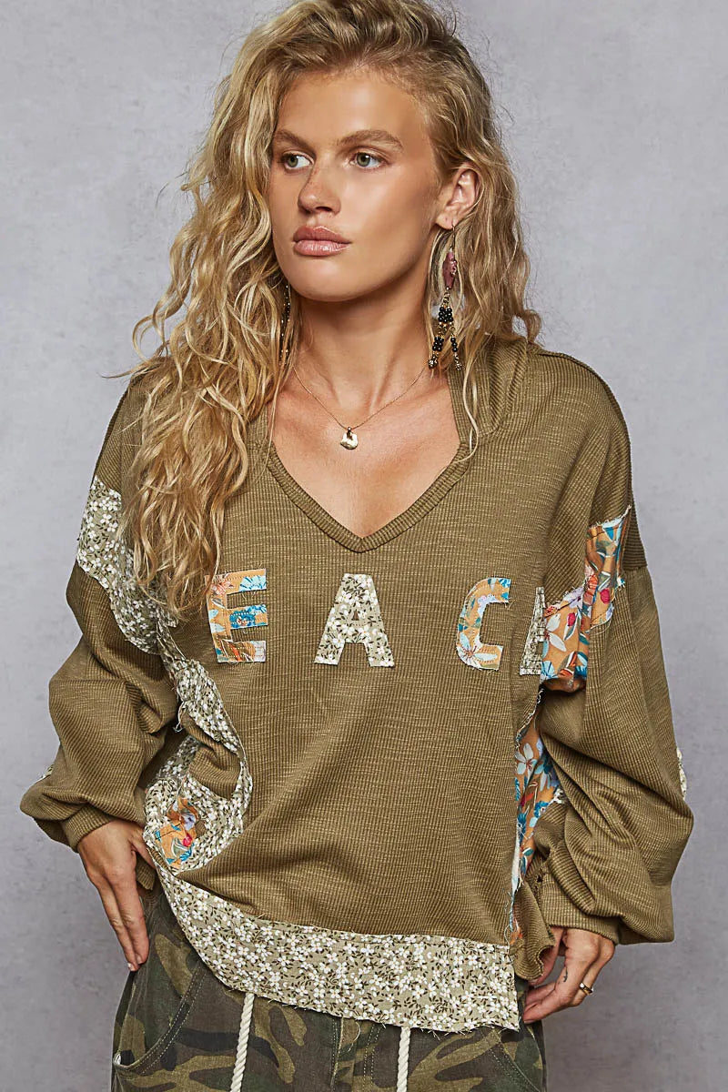 Model in relaxed V-neck hoodie styled with jeans outdoors