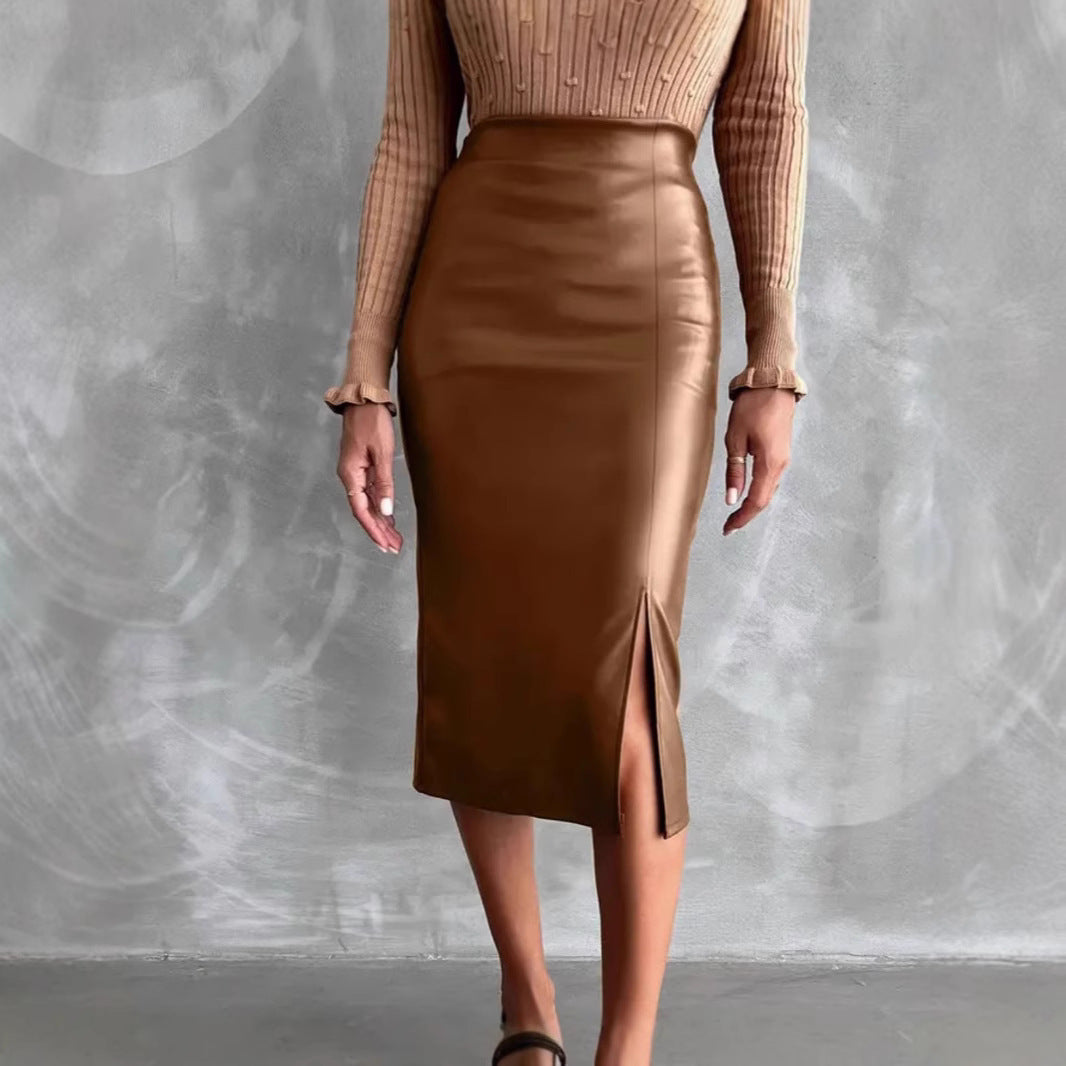 Woman striding in high waist leather skirt, camel hue glowing under light to accentuate the flattering high-rise and hip-hugging silhouette.