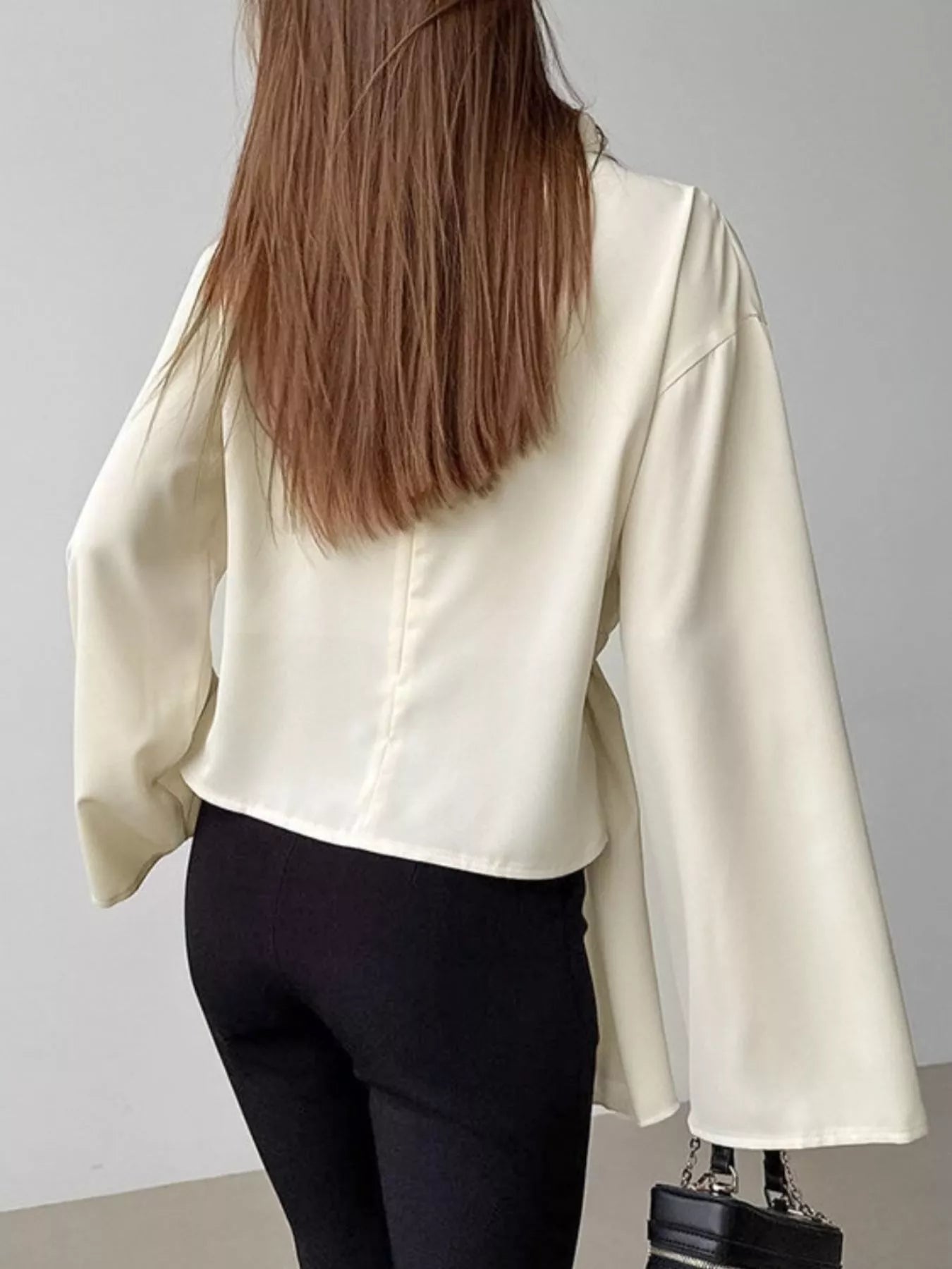 Ruched mock neck blouse front view showing asymmetrical ruching lines and fitted silhouette in lightweight polyester
