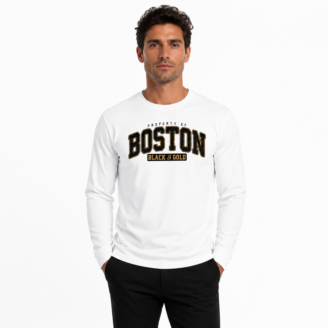 A man wearing a white long-sleeve t-shirt with a black and gold 'BOSTON BLACK GOLD' graphic on the chest, paired with black pants, against a plain white background.