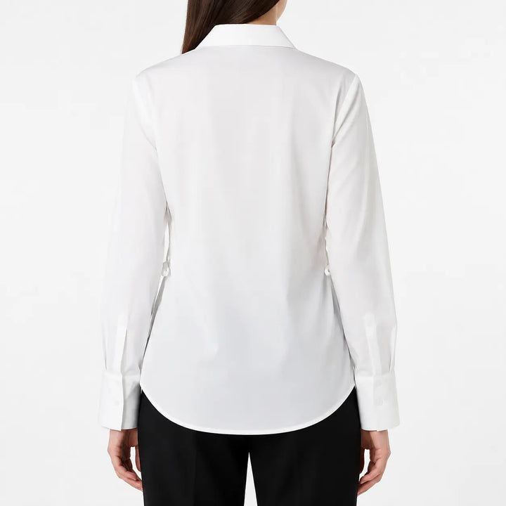 Back image of the white blouse on a female model, showing the plain rear panel, pointed collar, long sleeves, and curved hem.