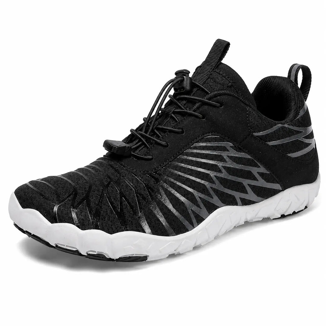 Black unisex slip-on hiking shoe close-up showing the mesh upper, elastic lace structure and low-cut profile detail on white.