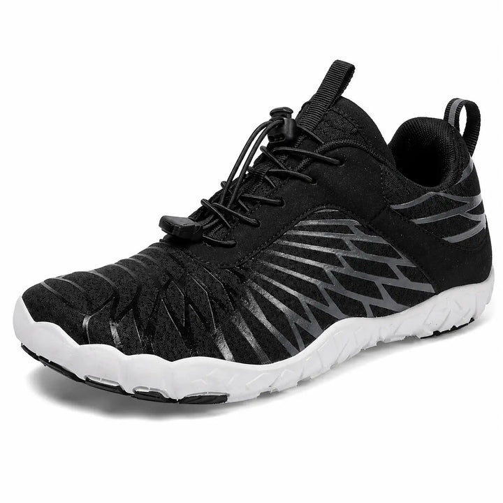 Black unisex slip-on hiking shoe close-up showing the mesh upper, elastic lace structure and low-cut profile detail on white.
