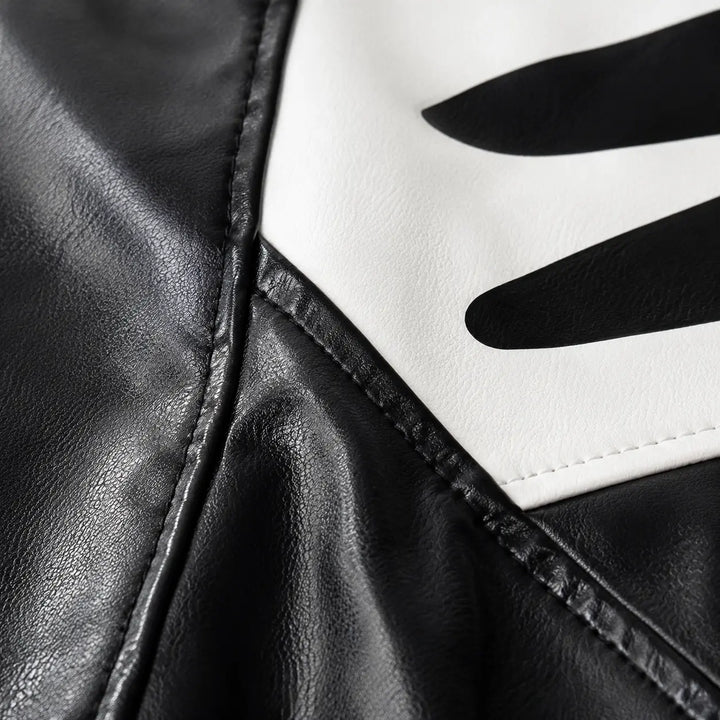 Close-up of Black-white colorblock jacket fabric, panel seams, printed graphic area and stitching details for product review.
