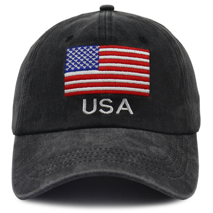 A washed black baseball cap featuring an embroidered American flag patch on the front with the letters &