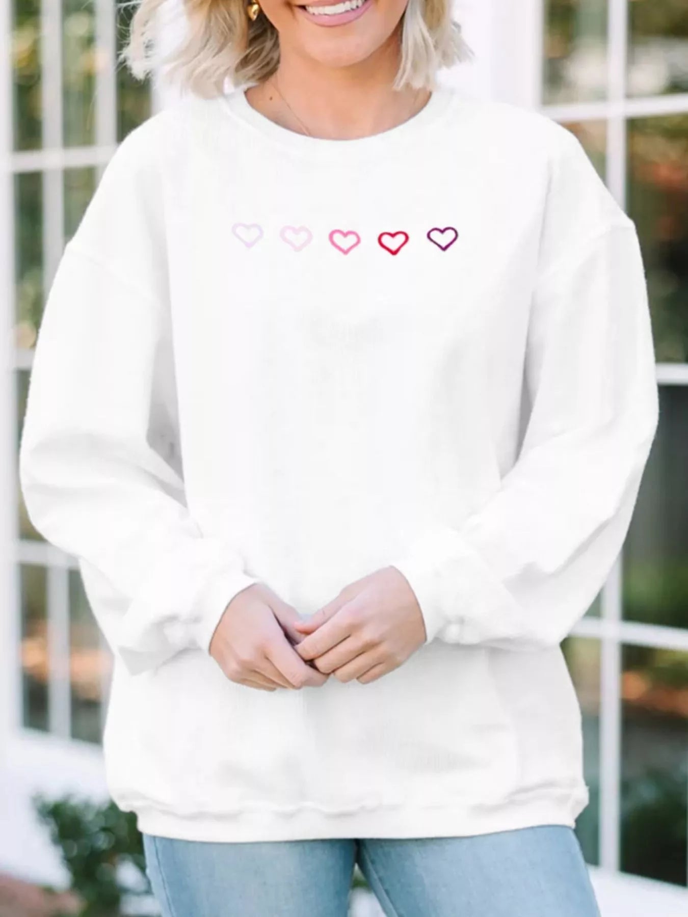 heart embroidered oversized sweatshirt flat lay with folded cuffs highlighting 98% cotton fabric texture and premium drape
