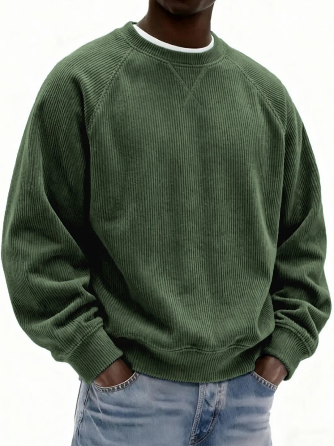 Person wearing a green corduroy sweater and blue jeans on a white background