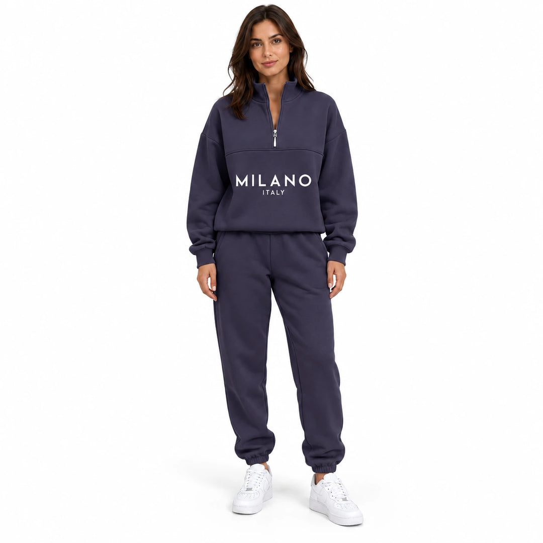 Woman wearing the dark purple half zip sweatshirt and matching joggers with white letter print