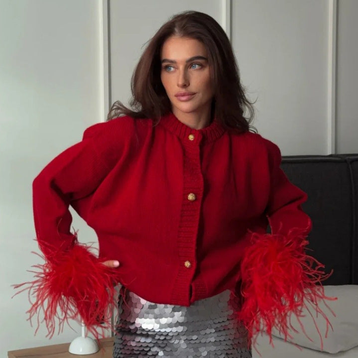 Red knit cardigan with feather cuffs and gold-tone buttons on a model, front view