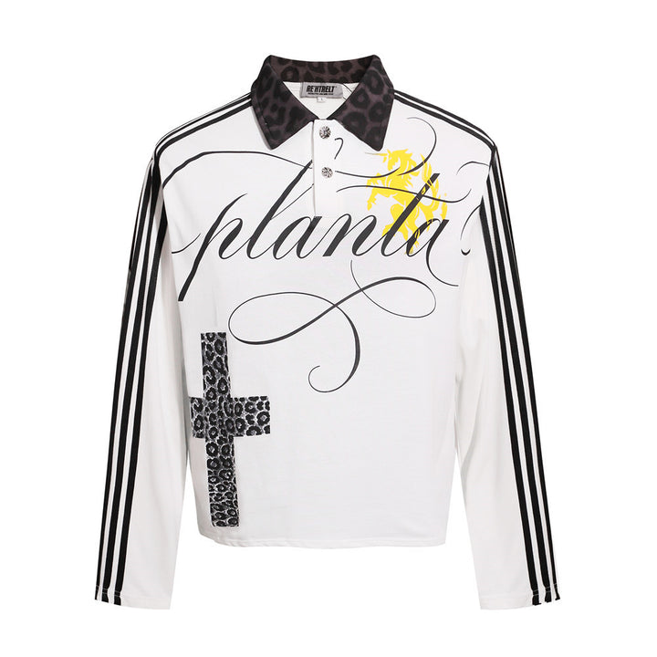 White gothic polo shirt, front view, with black sleeve stripes, leopard-pattern cross, black collar and a yellow chest motif.