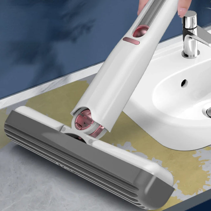 Cleaning tool with pink bristle head being used on a sink
