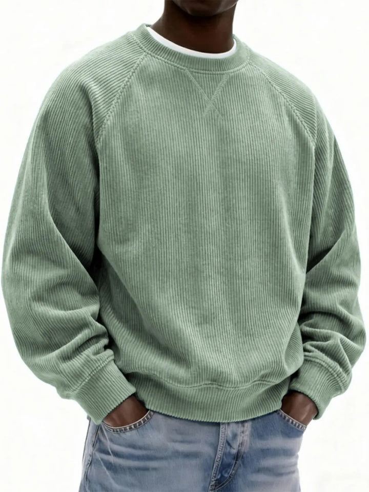 Person wearing a green sweater and blue jeans on a white background