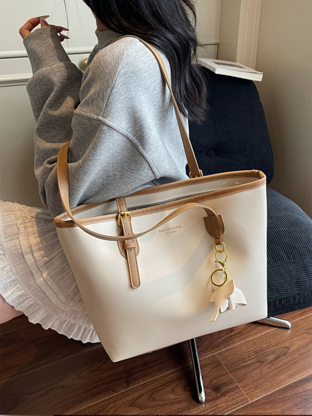 Lifestyle shot - woman carrying contrast shoulder bag over one shoulder during morning commute
