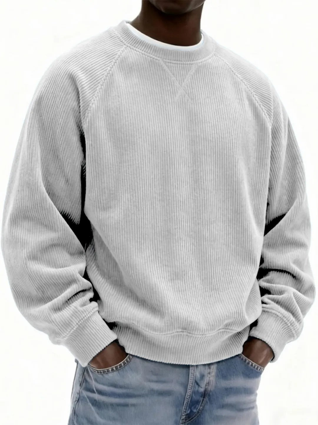 Person wearing a light gray sweatshirt and blue jeans on a white background