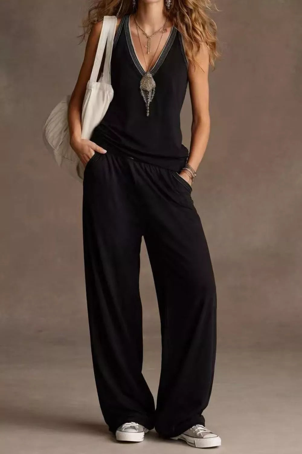 Person wearing a black jumpsuit with a plain background