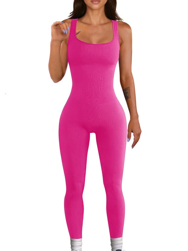 Woman wearing a bright pink ribbed jumpsuit on a white background
