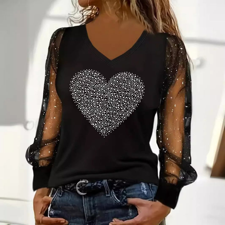 Original supplier photo of the black V-neck top with a solid rhinestone heart and sheer dotted mesh sleeves
