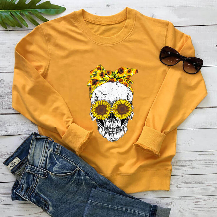 Yellow sunflower skull sweatshirt laid flat with jeans and sunglasses