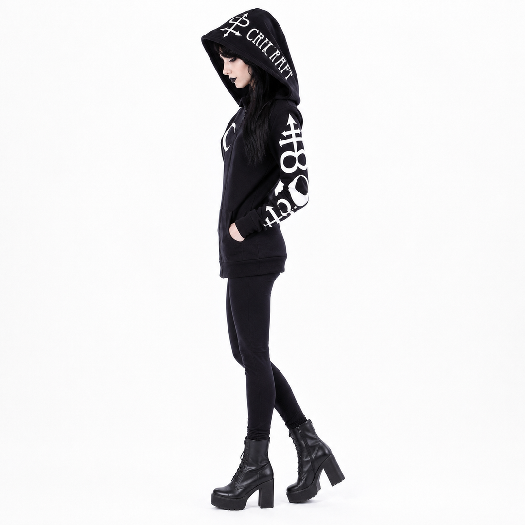 A model wearing a black hooded sweatshirt with white graphic text and symbols, paired with black leggings and black platform ankle boots, shown against a plain white background.