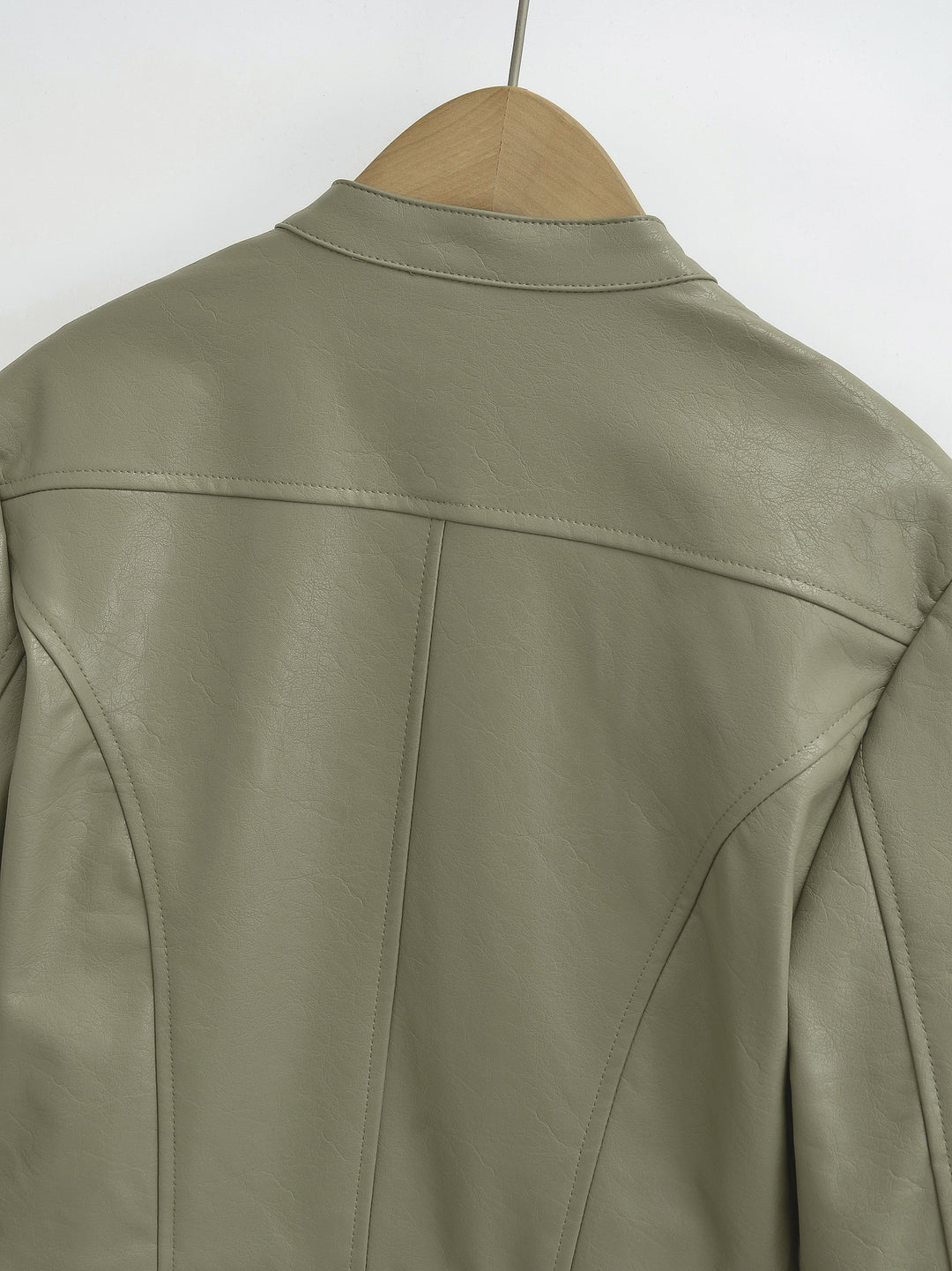 Gray Green jacket upper back on a hanger showing shoulder stitching with the stand collar, yoke and center seam in the photo.