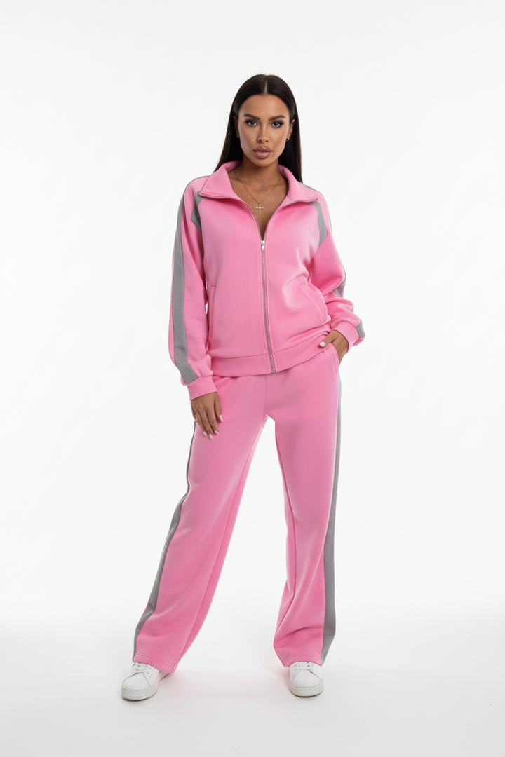 Woman in pink co-ord tracksuit set stretching outdoors, morning workout outfit, soft natural lighting
