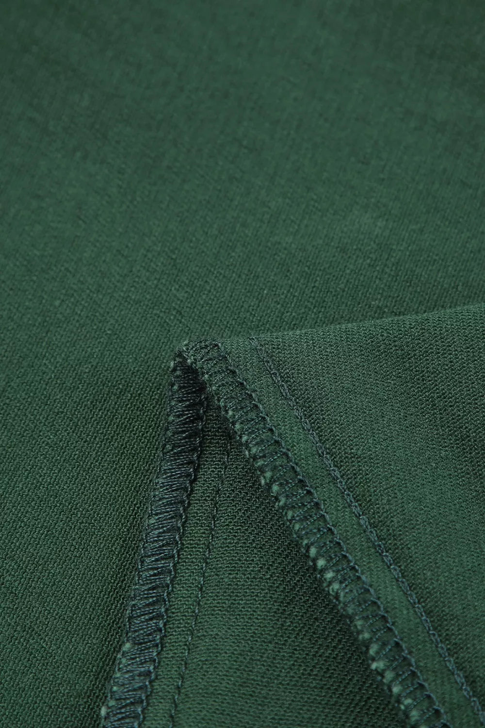 Close-up of green fabric with a visible seam