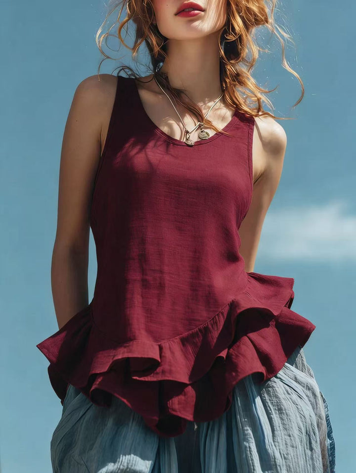 Woman wearing a burgundy ruffled top against a blue sky