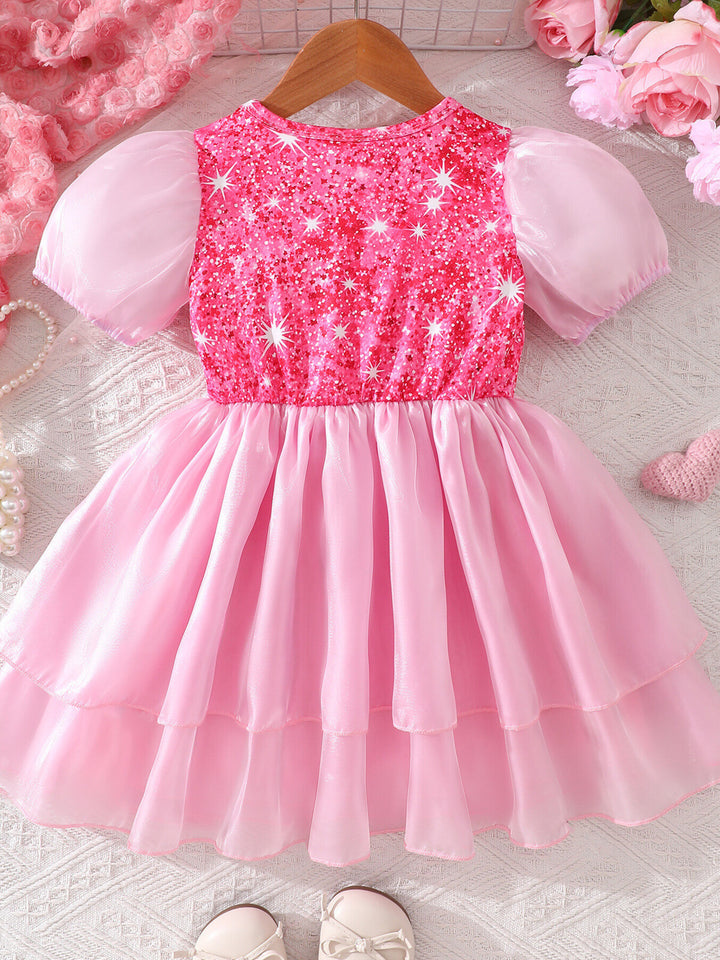 Pink sequin dress on a hanger with pink flowers in the background