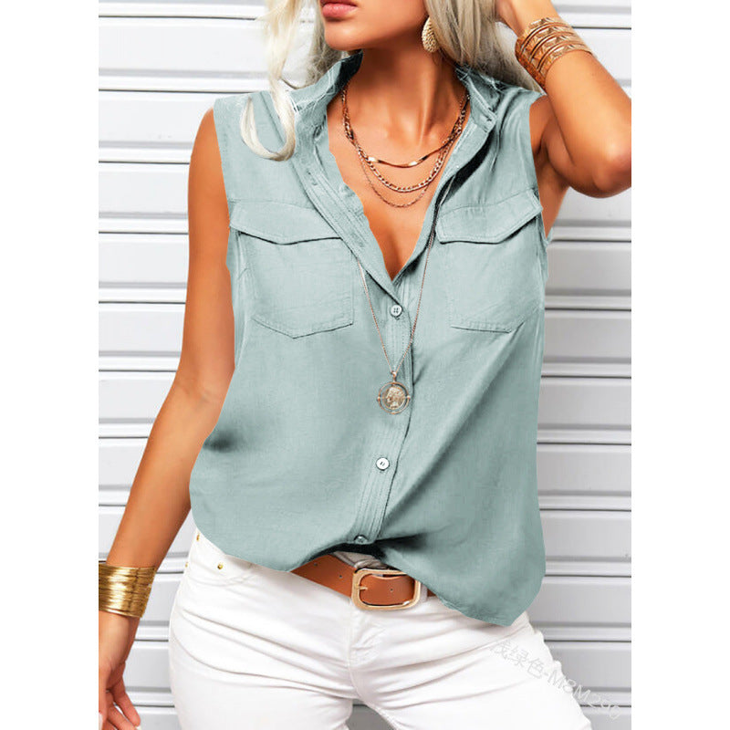 Woman wearing a light blue sleeveless button-up shirt with white pants against a white background