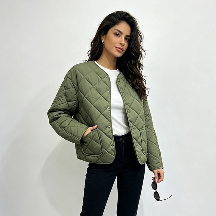 Green diamond-quilted jacket with one hand in its patch pocket
