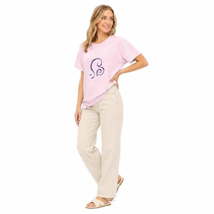 A woman modeling a light pink short-sleeve t-shirt with a purple and blue spiral graphic on the chest, paired with beige wide-leg pants and beige sandals, against a solid white background.