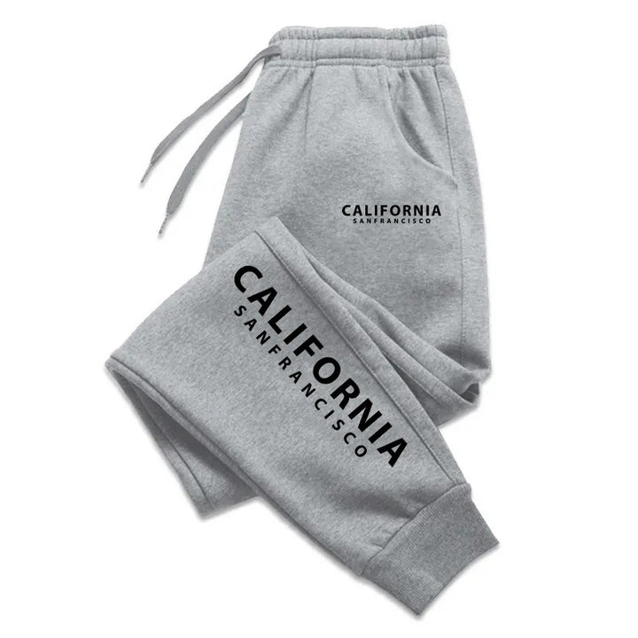 Heather gray California print sweatpants with black lettering, drawstrings and ankle cuffs, folded on a plain white backdrop.