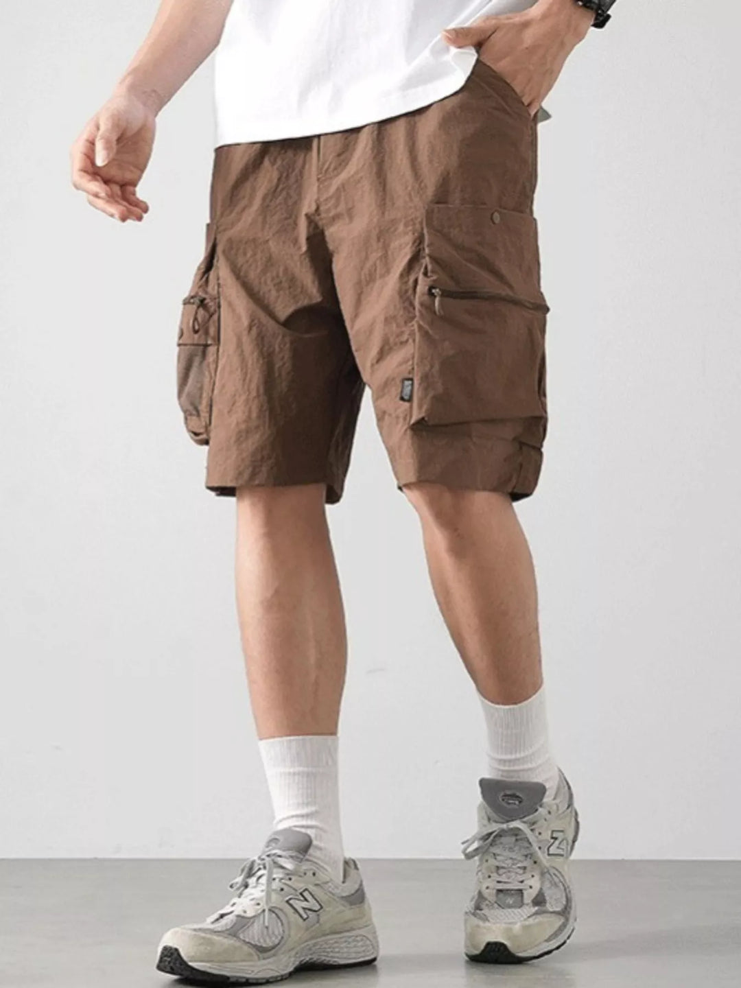 Streetwear cargo shorts for men paired with graphic tee and chunky sneakers
