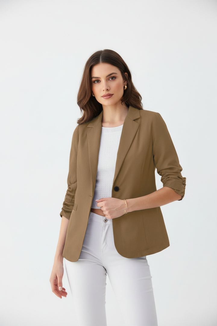 Woman wearing a brown blazer over a white top and pants on a white background