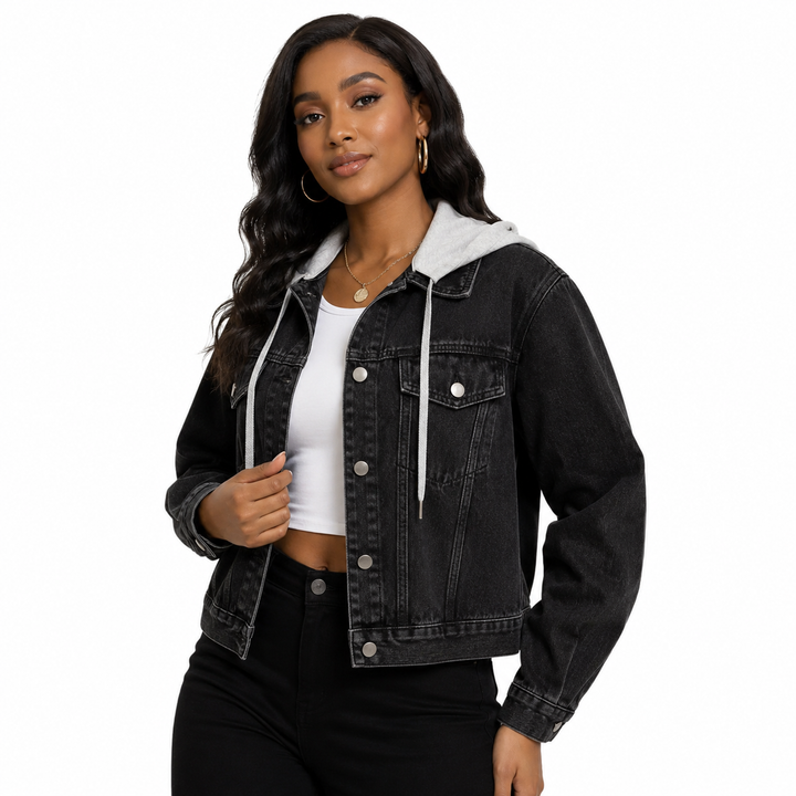 A woman modeling a black washed denim hooded jacket with a white hood lining, worn open over a white crop top and black pants, against a plain white background.