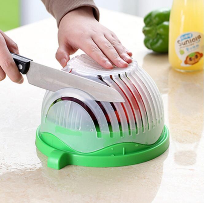 Creative salad cutter bowl with green lid and white base on a wooden kitchen counter
