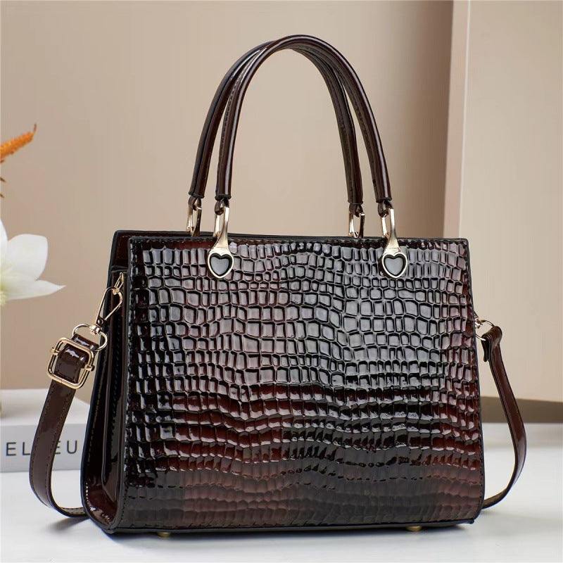 Brown textured handbag with gold accents on a light background