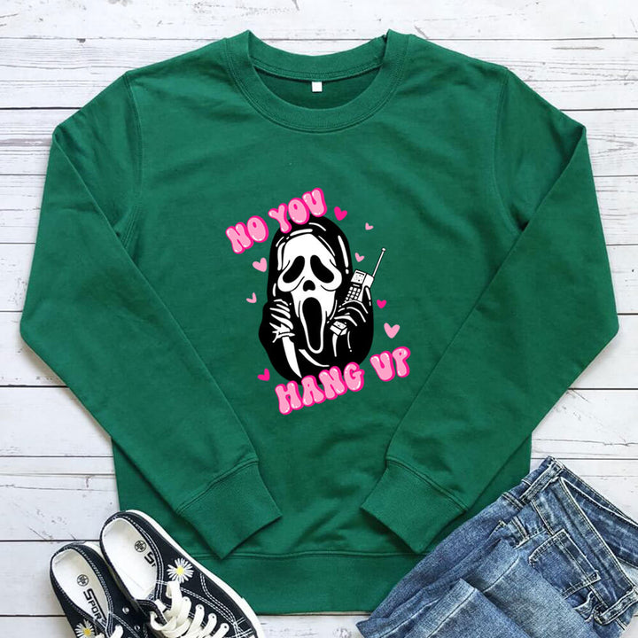 Original image: Green printed crewneck sweatshirt laid flat beside a pair of jeans pictured with the garment details visible.