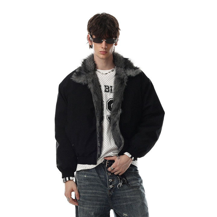 Black bomber jacket worn open on a male model, showing the grey faux fur collar, silver zip and gathered hem in a front view.