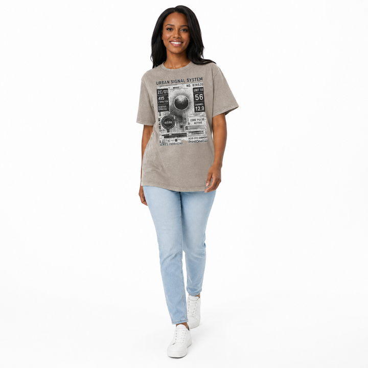 Woman walking in a dark khaki acid wash graphic T shirt with Urban Signal System print, light jeans and white sneakers.
