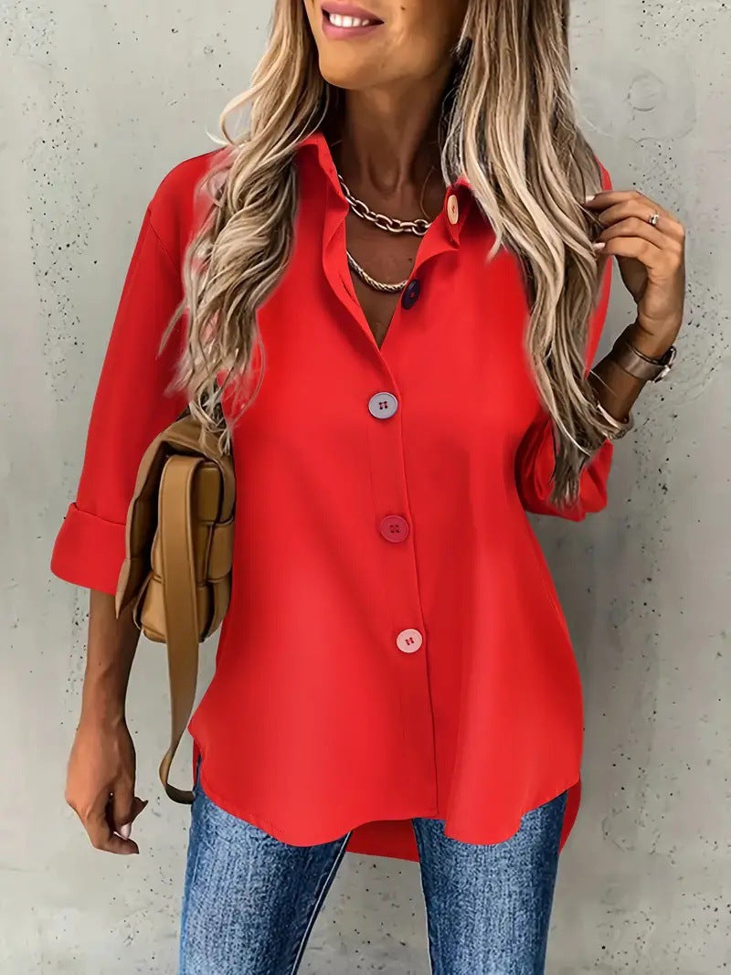 Woman wearing a red blouse and blue jeans against a plain background