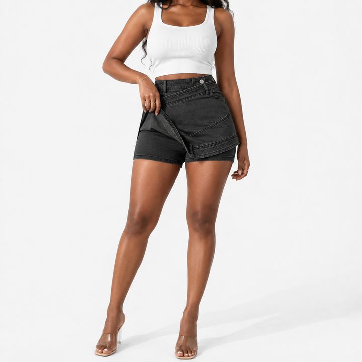 A model wearing black denim wrap shorts, a white crop top, and clear high-heeled sandals, standing against a plain white studio background.
