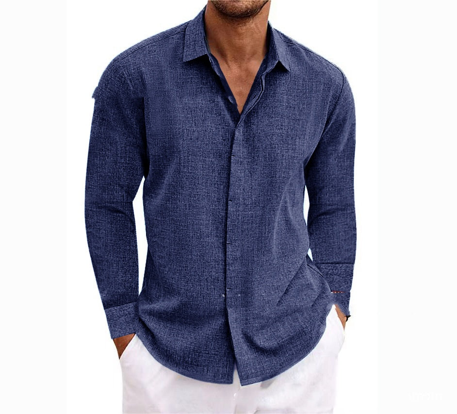Man wearing a blue button-up shirt with white pants on a white background