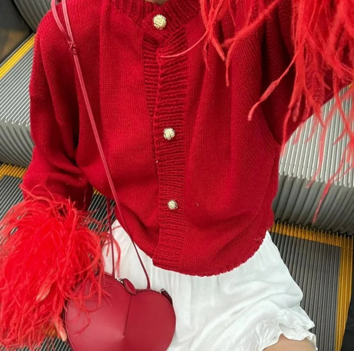 Close model view of the red cardigan knit, buttons and feather cuffs
