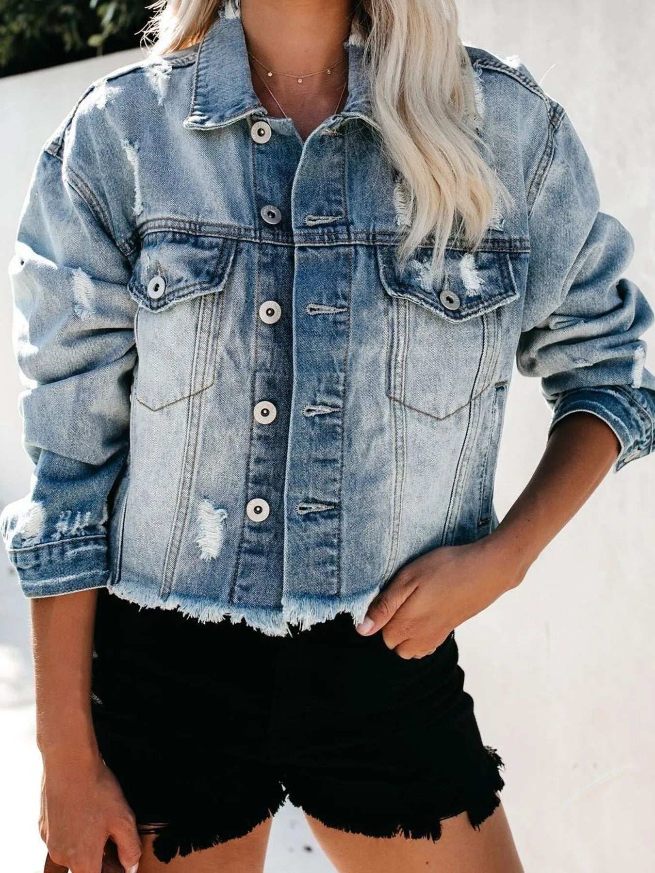 Back view of washed women’s denim jacket with cat's whisker effect


