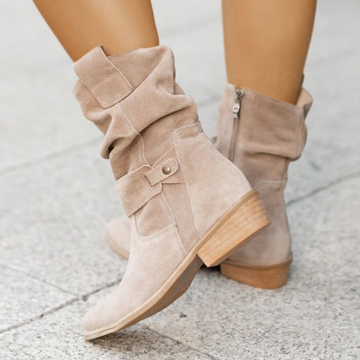 Brown suede boot lifestyle shot with autumn leaves

