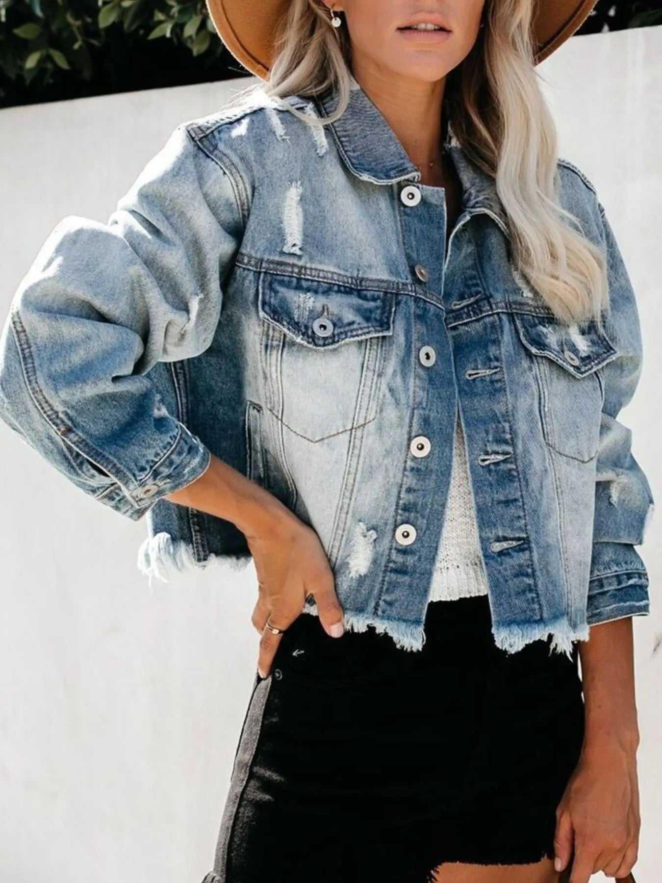 Close-up of button front detail on women's distressed denim jacket

