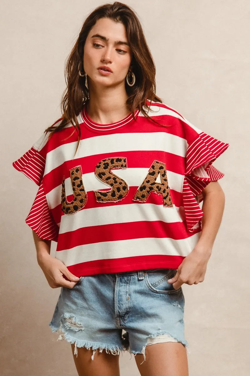 Close-up of BiBi blouse's playful ruffle sleeve and graphic detail

