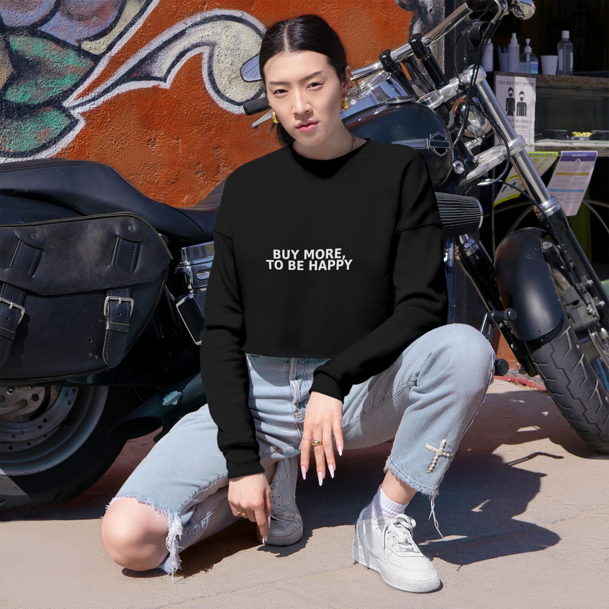 Cropped sweatshirt with dropped shoulders and textured knit fabric, displayed on a rustic wood surface.

