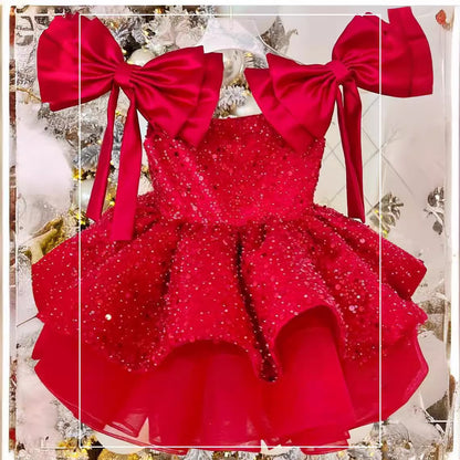 Flat-lay – red and champagne Princess Dresses with matching hair bow

